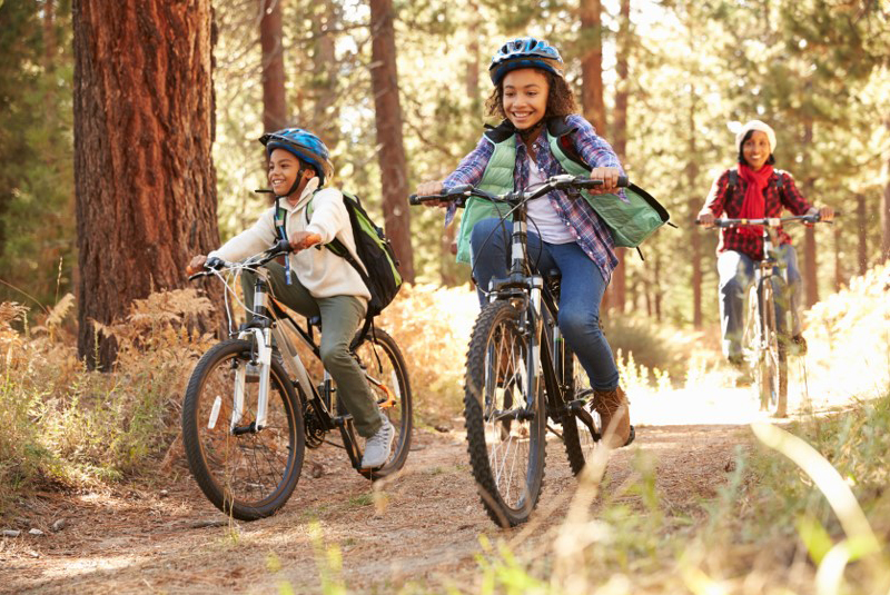 2 enfants à vélo dans la forêt avec leur mère