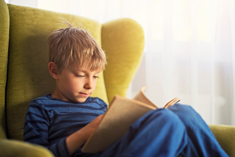 Un garçon lit un livre