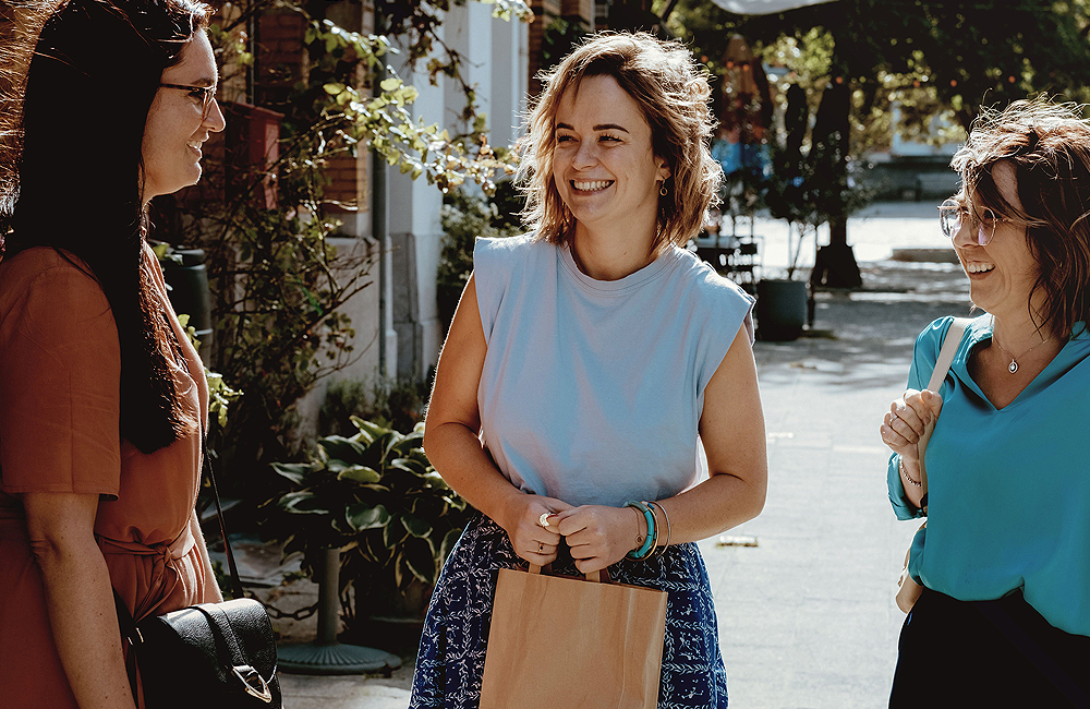 3 jeunes femmes ont une conversation agréable dans la rue